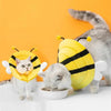 Collerette Chat en Forme d'Abeille Douce et Confortable portée par des chats sur une table blanche avec un mur orange en fond
