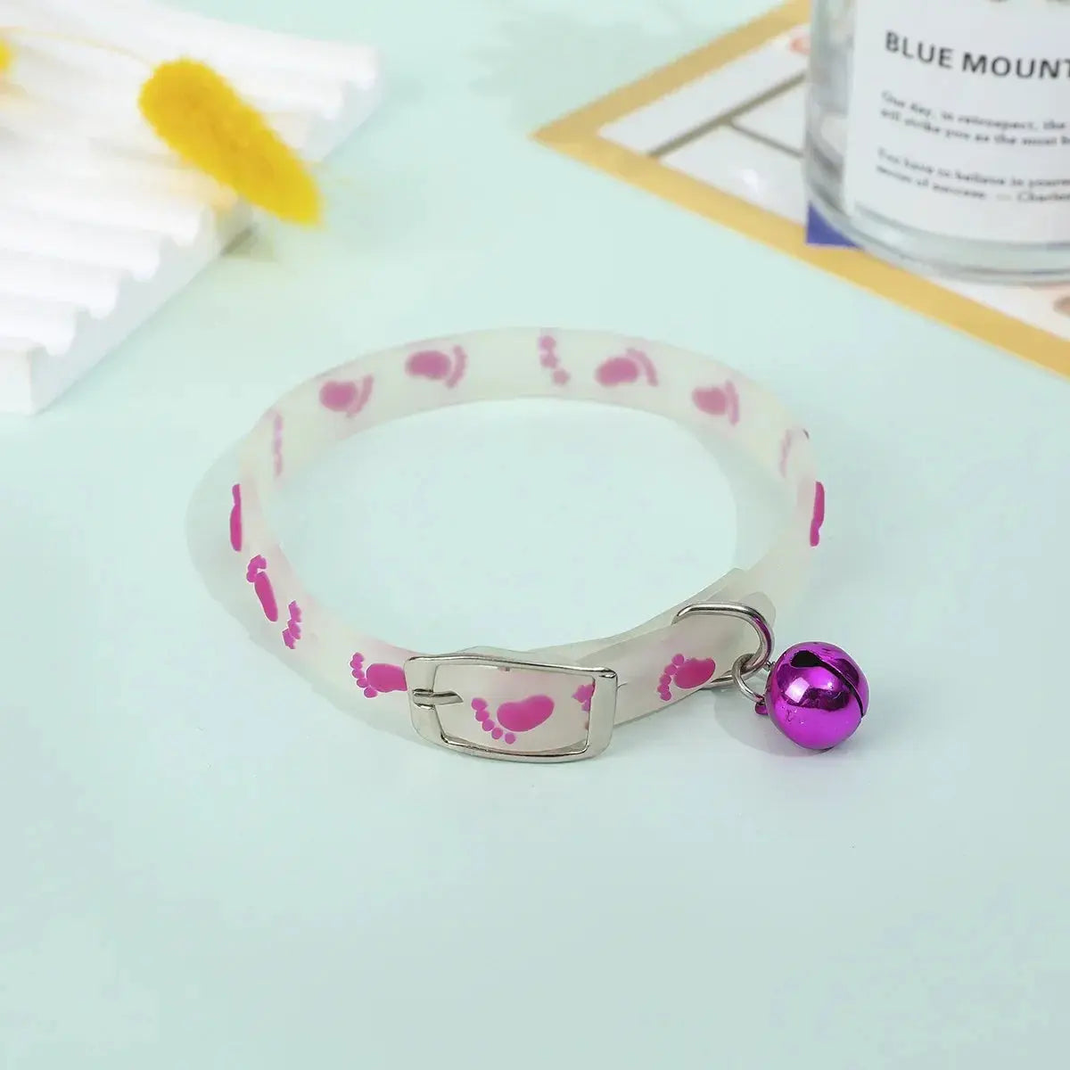 Collier Chat Anti Étranglement Fluorescent avec Clochette sur fond bleu avec des accessoires derrière
