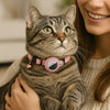 Collier GPS Chat - Support Airtag, Collier de Suivi Anti Perte : en rose porté par un chat marron gris tenu par une jeune femme aux cheveux longs et pull beige