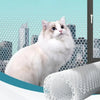 Filet de Protection Chat pour Balcon et Fenêtre avec un chat blanc devant une fenêtre avec un rouleau de protection à côté