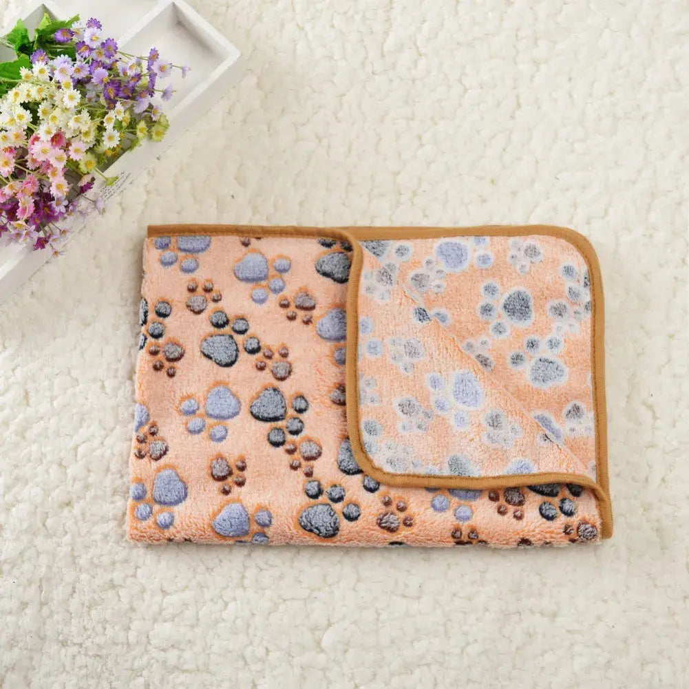 Tapis Rafraichissant Chat avec Motifs en Forme de Pattes posé sur un tapis blanc avec des fleurs à gauche