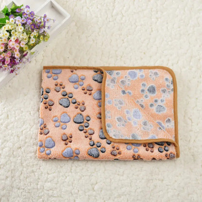 Tapis Rafraichissant Chat avec Motifs en Forme de Pattes posé sur un tapis blanc avec des fleurs à gauche