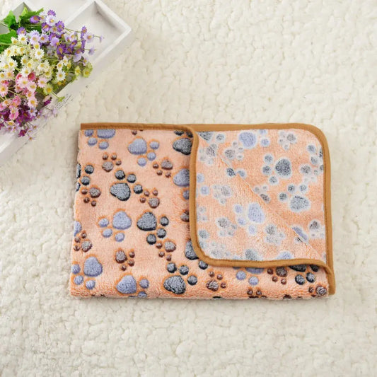 Tapis Rafraichissant Chat avec Motifs en Forme de Pattes posé sur un tapis blanc avec des fleurs à gauche