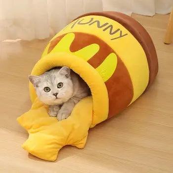niche chat coussin lit  jolivase une niche au sol avec un chat dedans, sur sol lattes en bois et rideaux blancs