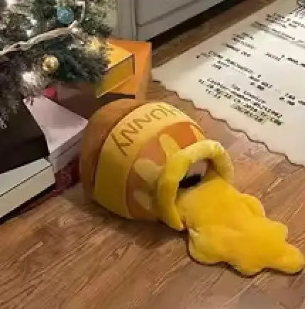 niche chat coussin lit  jolivase une niche au sol avec un chat caché dedans, un tapis blanc avec textes noirs et un sapin de Noël